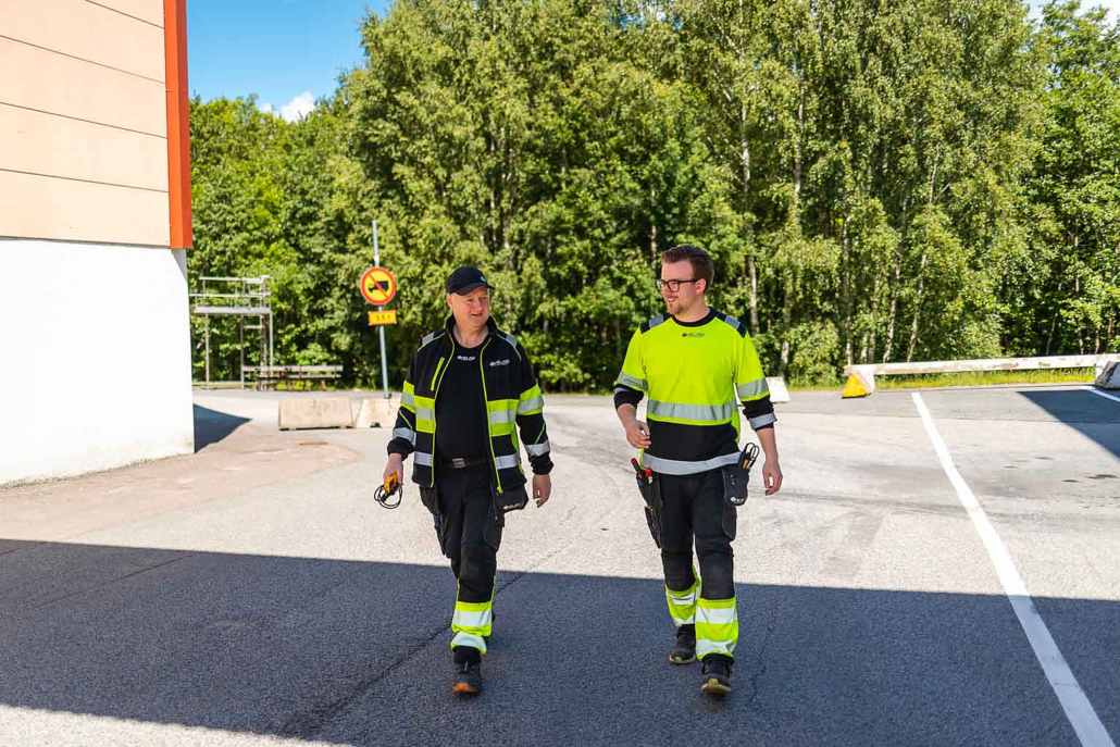 Två medarbetare från Helab på väg över en arbetsplats.